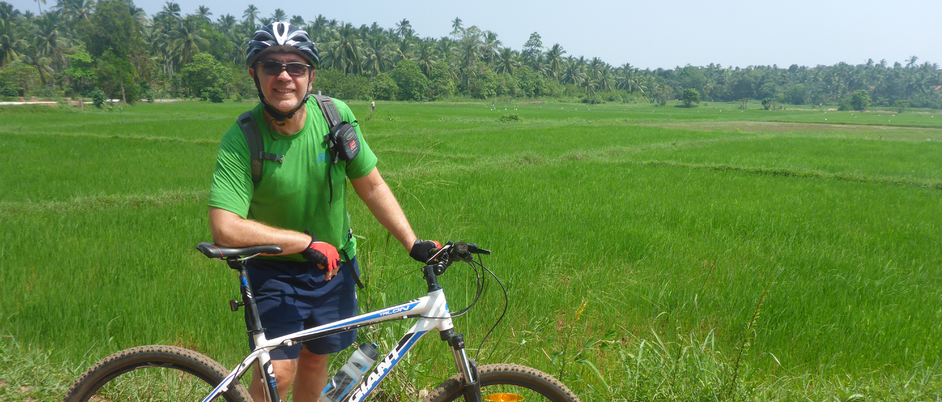 happy cyclist in Sri Lanka stop at Paddy field 
